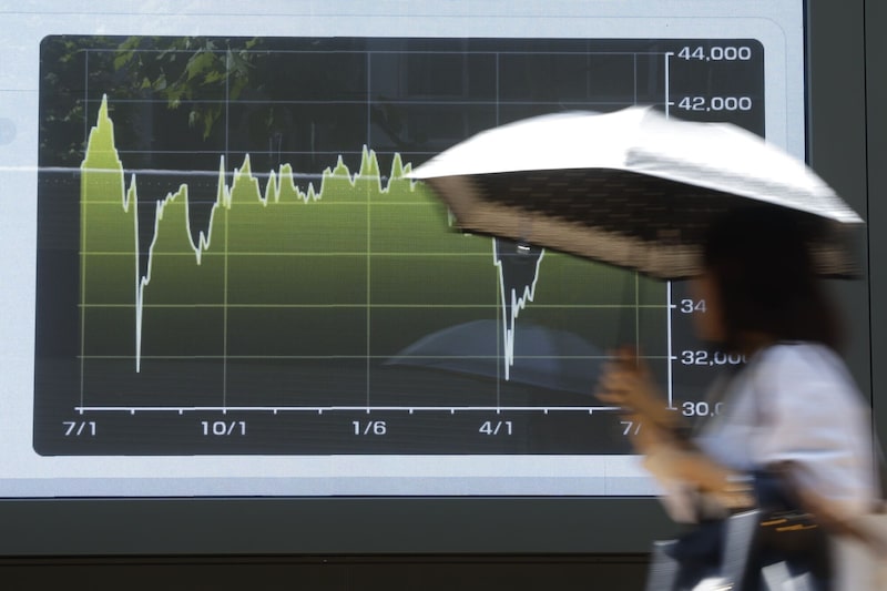Una pantalla muestra un gráfico con la evolución del índice bursátil Nikkei 225 fuera de una empresa de valores en Tokio, Japón. Una pantalla muestra un gráfico con la evolución del índice bursátil Nikkei 225 fuera de una empresa de valores en Tokio, Japón.