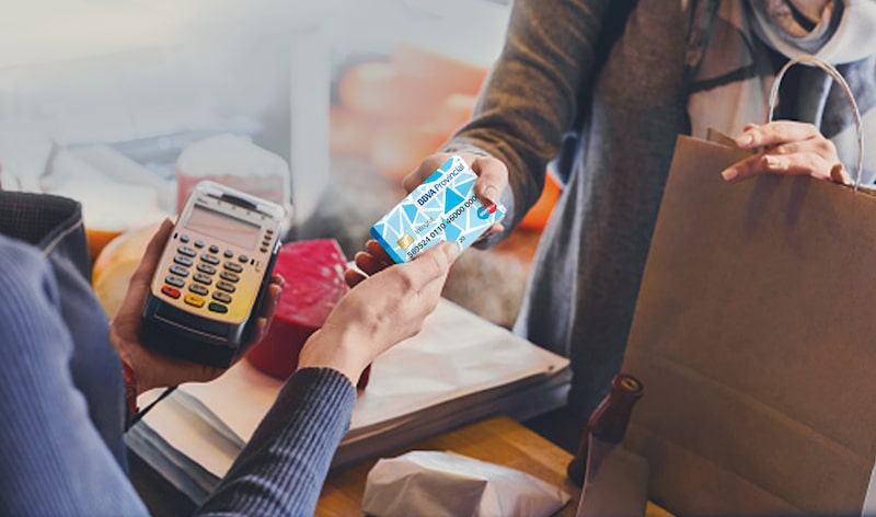 Una consumidora paga sus compras con su tarjeta de crédito. Una consumidora paga sus compras con su tarjeta de crédito.