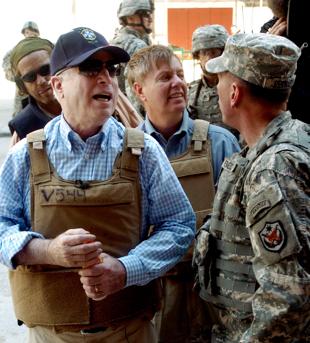 Republican U.S. senators John McCain of Arizona, left, and Lindsey Graham of South Carolina, center, confer with General David Petraeus, U.S. Commander in Iraq, during an April 1 tour of the Shorga marketplace in Baghdad, Iraq. Photographer: Sgt. Matthew Roe. Source: U.S. Army via Bloomberg News. Republican U.S. senators John McCain of Arizona, left, and Lindsey Graham of South Carolina, center, confer with General David Petraeus, U.S. Commander in Iraq, during an April 1 tour of the Shorga marketplace in Baghdad, Iraq. Photographer: Sgt. Matthew Roe. Source: U.S. Army via Bloomberg News.