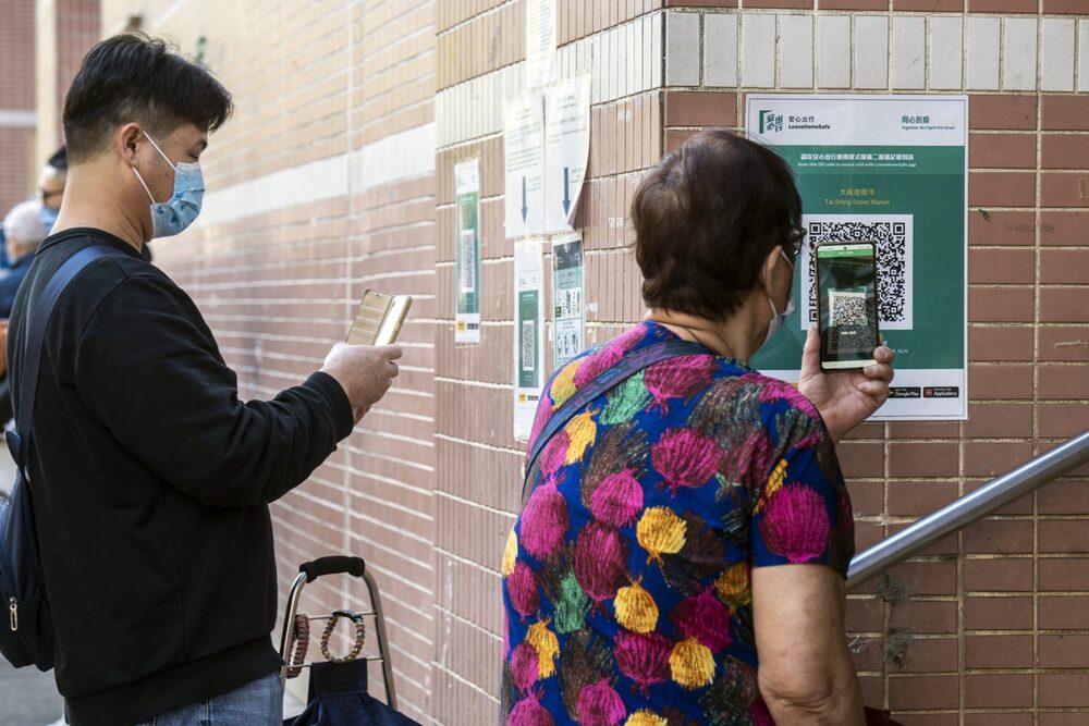Consumidores escaneiam QR codes para o aplicativo LeaveHomeSafe Covid-19 antes de entrar em um mercado em Hong Kong (Chan Long Hei/Bloomberg) Consumidores escaneiam QR codes para o aplicativo LeaveHomeSafe Covid-19 antes de entrar em um mercado em Hong Kong (Chan Long Hei/Bloomberg)