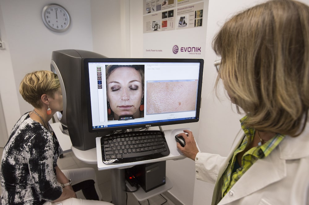 laboratory technician, right, uses a desktop computer as anti-aging facial skincare testing is carried out on a VISIA-CR Facial Imaging Booth, manufactured by Canfield Imaging Systems, in the innovation-center for cosmetic ingredients at the Evonik Industries AG laboratory in Essen, Germany, on Tuesday, June 10, 2014. Evonik's controlling shareholder, RAG-Stiftung, may sell a 2.2 percent stake in the German chemical maker through an issue of exchangeable bonds to raise funds for investment. Photographer: Martin Leissl/Bloomberg laboratory technician, right, uses a desktop computer as anti-aging facial skincare testing is carried out on a VISIA-CR Facial Imaging Booth, manufactured by Canfield Imaging Systems, in the innovation-center for cosmetic ingredients at the Evonik Industries AG laboratory in Essen, Germany, on Tuesday, June 10, 2014. Evonik's controlling shareholder, RAG-Stiftung, may sell a 2.2 percent stake in the German chemical maker through an issue of exchangeable bonds to raise funds for investment. Photographer: Martin Leissl/Bloomberg