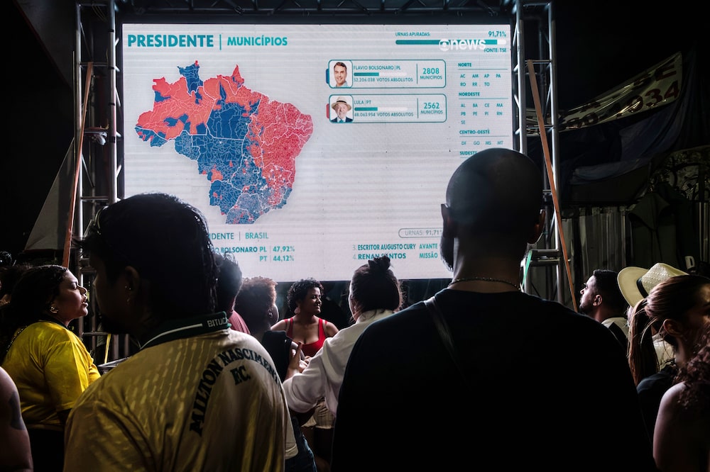 Voting results on a screen during an election night party in Brasilia, Brazil, on Sunday, Oct. 4, 2026. Flavio Bolsonaro unexpectedly finished ahead of President Lula in the first round of Brazils presidential election while conservative allies dominated downballot, setting the nation up for a sharp shift to the right. Photographer: Dado Galdieri/Bloomberg Voting results on a screen during an election night party in Brasilia, Brazil, on Sunday, Oct. 4, 2026. Flavio Bolsonaro unexpectedly finished ahead of President Lula in the first round of Brazils presidential election while conservative allies dominated downballot, setting the nation up for a sharp shift to the right. Photographer: Dado Galdieri/Bloomberg