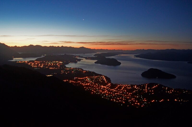 Las luces de la ciudad y el lago Nahuel Huapi, protagonista de la Patagonia argentina. Las luces de la ciudad y el lago Nahuel Huapi, protagonista de la Patagonia argentina.