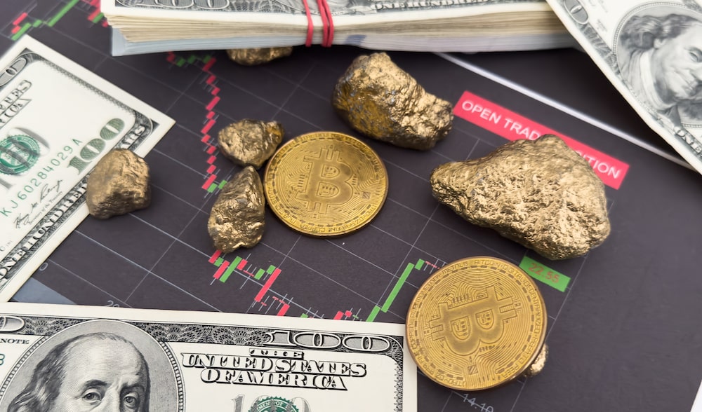 Bitcoin, oro y dólares sobre un gráfico de mercados financieros. Foto: Shutterstock. Bitcoin, oro y dólares sobre un gráfico de mercados financieros. Foto: Shutterstock.