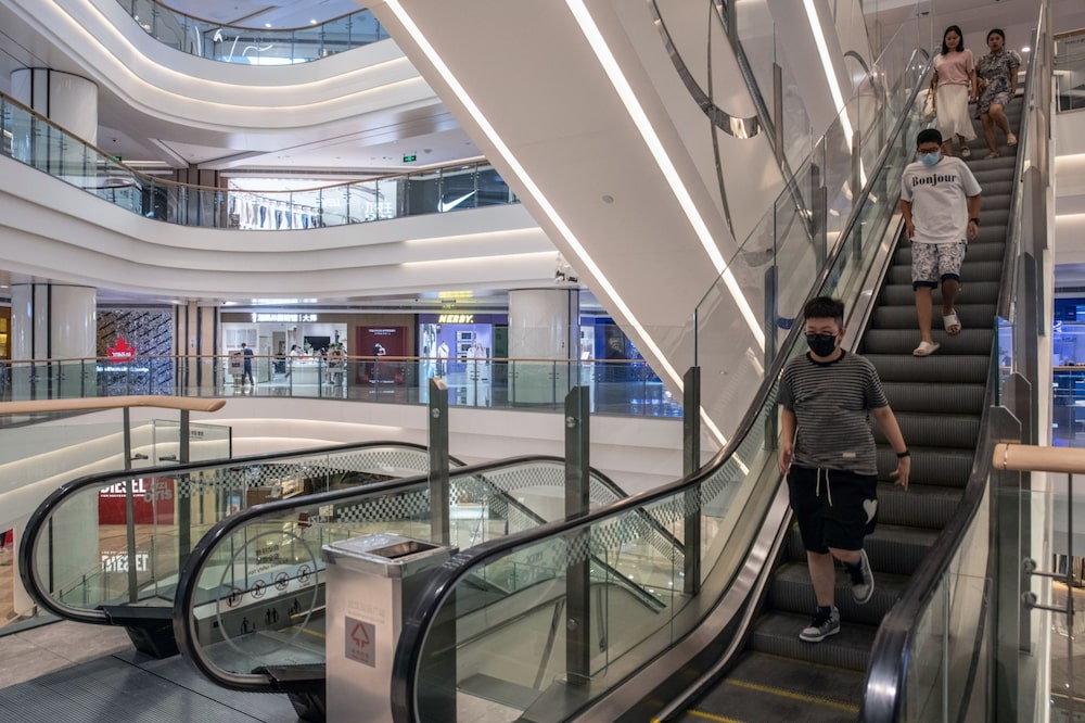 Los compradores bajan por una escalera mecánica, cerrada temporalmente para preservar la electricidad, en un centro comercial de Wuhan el 22 de agosto. Fuente: Bloomberg Los compradores bajan por una escalera mecánica, cerrada temporalmente para preservar la electricidad, en un centro comercial de Wuhan el 22 de agosto. Fuente: Bloomberg