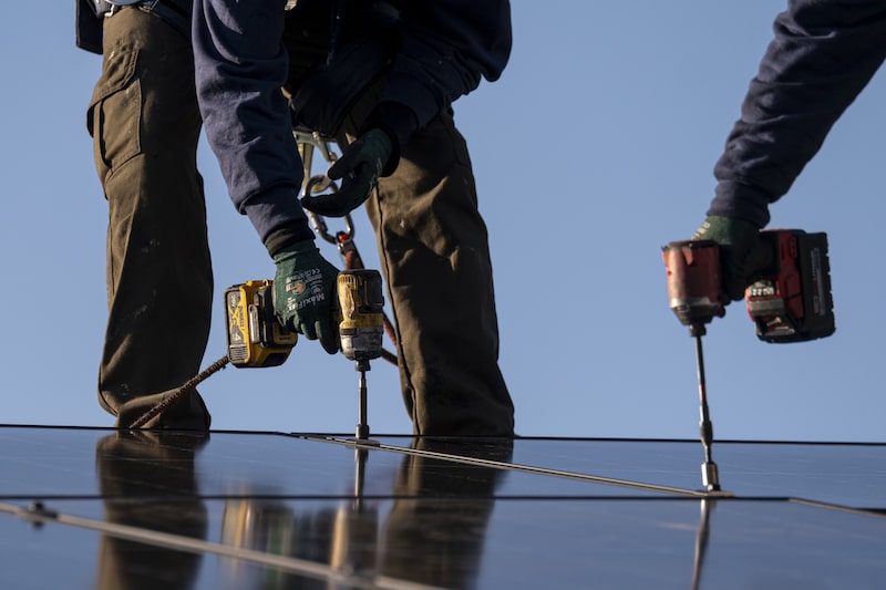 Trabajadores instalan paneles solares en un techo en San Jose, California Trabajadores instalan paneles solares en un techo en San Jose, California