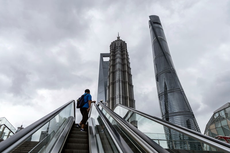 Foto de referencia. Un peatón en una escalera mecánica frente a un edificio en el distrito financiero de Lujiazui de Pudong en Shanghái, China. Foto de referencia. Un peatón en una escalera mecánica frente a un edificio en el distrito financiero de Lujiazui de Pudong en Shanghái, China.