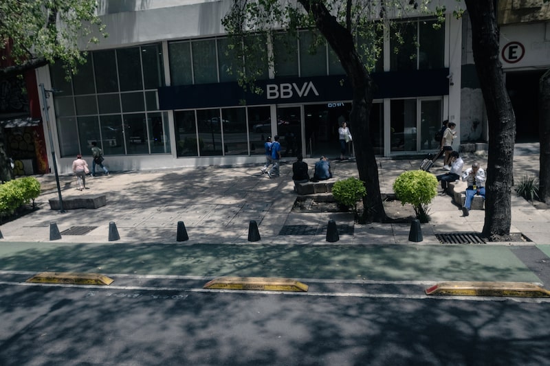 Pedestrians walk past a BBVA bank branch in Mexico City, Mexico, on Monday, July 14, 2025. The Mexican peso slumped further Monday morning, leading losses among emerging-market currencies following Donald Trump's weekend threat to impose 30% tariffs on the country. Photographer: Mayolo Lopez Gutierrez/Bloomberg. Pedestrians walk past a BBVA bank branch in Mexico City, Mexico, on Monday, July 14, 2025. The Mexican peso slumped further Monday morning, leading losses among emerging-market currencies following Donald Trump's weekend threat to impose 30% tariffs on the country. Photographer: Mayolo Lopez Gutierrez/Bloomberg.