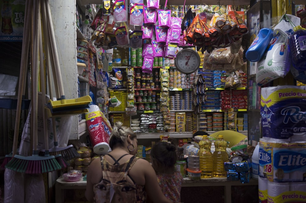 Una mujer y un niño compran varios productos en un mercado en el barrio Prado de Medellín, Colombia. Una mujer y un niño compran varios productos en un mercado en el barrio Prado de Medellín, Colombia.