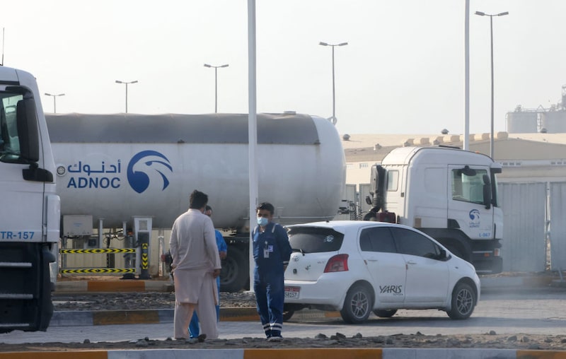 Hombres frente a una instalación de almacenamiento de la petrolera ADNOC en la capital de los Emiratos Árabes Unidos, Abu Dabi, el 17 de enero de 2022. Hombres frente a una instalación de almacenamiento de la petrolera ADNOC en la capital de los Emiratos Árabes Unidos, Abu Dabi, el 17 de enero de 2022.
