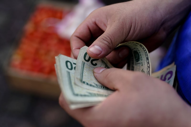 Un vendedor cuenta billetes de dólar estadounidense durante un evento de venta de alimentos al por mayor en la Plaza Centenario en Quezaltepeque, departamento de La Libertad, El Salvador, el martes 9 de julio de 2024. Foto: Camilo Freedman/Bloomberg Un vendedor cuenta billetes de dólar estadounidense durante un evento de venta de alimentos al por mayor en la Plaza Centenario en Quezaltepeque, departamento de La Libertad, El Salvador, el martes 9 de julio de 2024. Foto: Camilo Freedman/Bloomberg