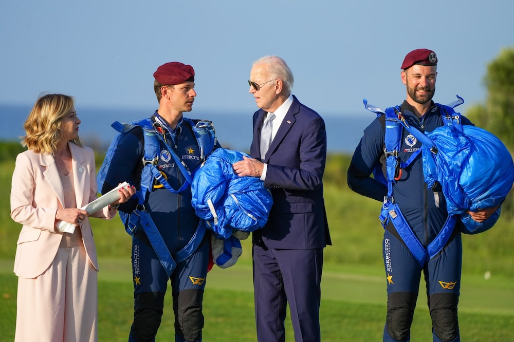 Meloni y Biden conversan con paracaidistas tras una exhibición en la jornada inaugural del G-7. Meloni y Biden conversan con paracaidistas tras una exhibición en la jornada inaugural del G-7.