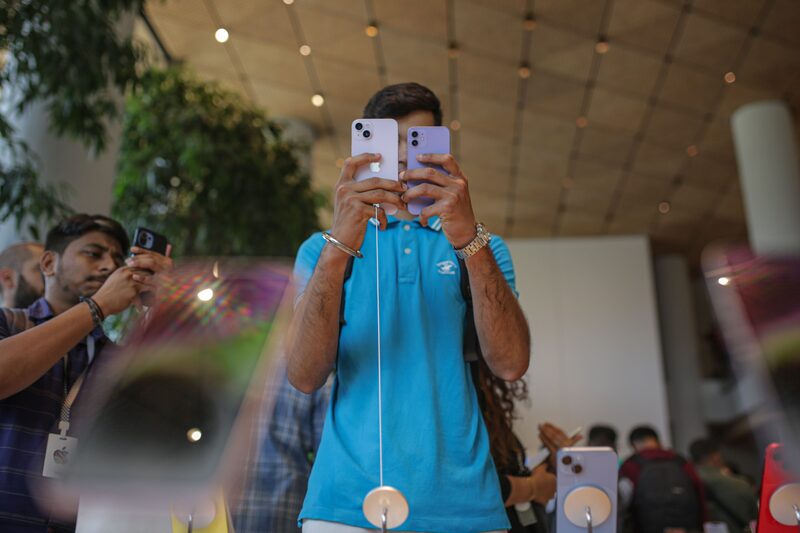 Un cliente mira iPhones en una tienda Apple. Un cliente mira iPhones en una tienda Apple.