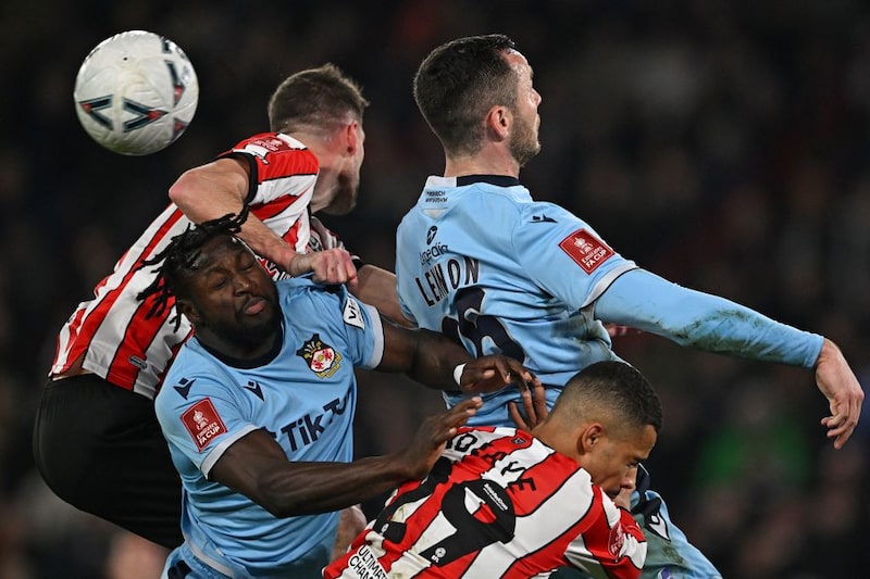 El defensa español del Wrexham Jacob Mendy (izquierda) y su compañero, el defensa inglés del Wrexham Harry Lennon (arriba a la derecha). El defensa español del Wrexham Jacob Mendy (izquierda) y su compañero, el defensa inglés del Wrexham Harry Lennon (arriba a la derecha).