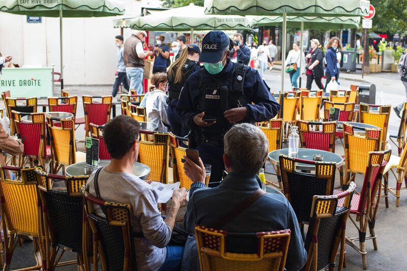 Policial verifica documentos de saúde em restaurante de Paris Policial verifica documentos de saúde em restaurante de Paris