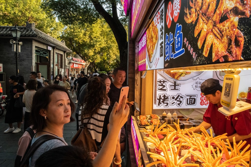 A woman uses a digital payment service to buy food in Beijing on Aug. 12. A woman uses a digital payment service to buy food in Beijing on Aug. 12.