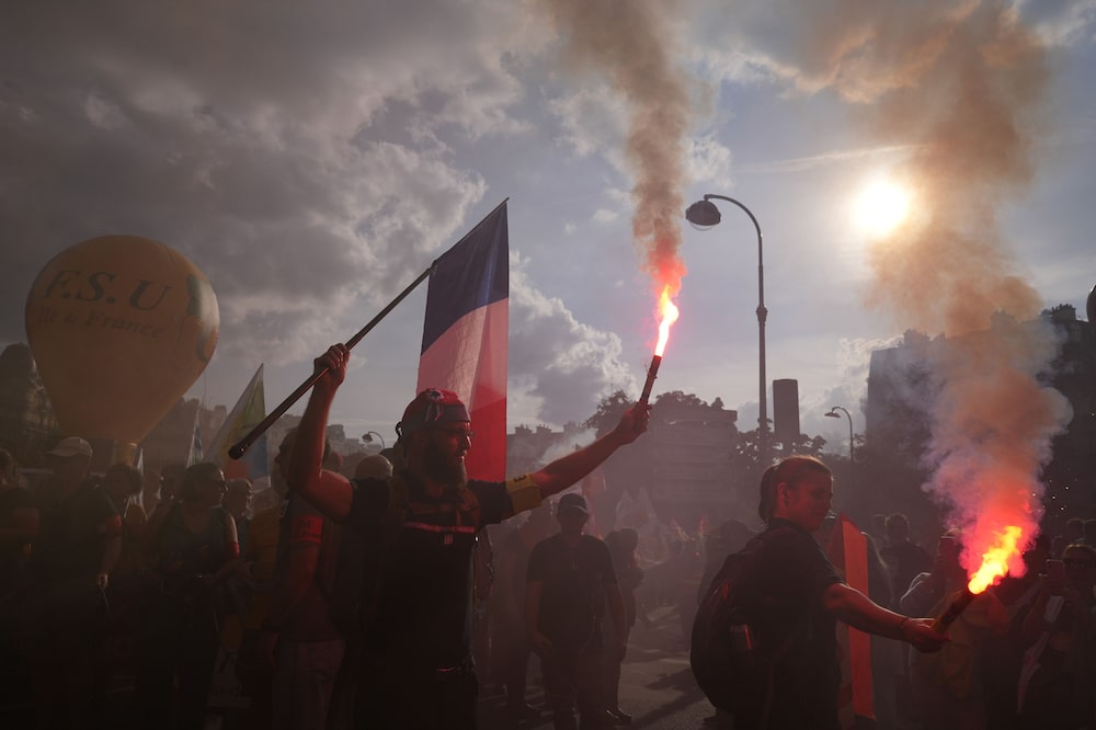 Manifestantes con bengalas y una bandera nacional durante una protesta contra el proyecto de presupuesto del gobierno en París, Francia, el 29 de septiembre. Manifestantes con bengalas y una bandera nacional durante una protesta contra el proyecto de presupuesto del gobierno en París, Francia, el 29 de septiembre.