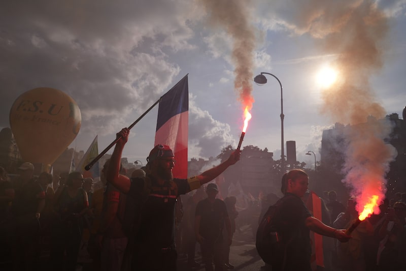 Manifestantes con bengalas y una bandera nacional durante una protesta contra el proyecto de presupuesto del gobierno en París, Francia, el 29 de septiembre. Fotógrafo: Nathan Laine/Bloomberg Manifestantes con bengalas y una bandera nacional durante una protesta contra el proyecto de presupuesto del gobierno en París, Francia, el 29 de septiembre. Fotógrafo: Nathan Laine/Bloomberg
