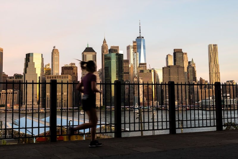 Una persona corre frente al horizonte de Manhattan, con el One World Trade Center al fondo. Una persona corre frente al horizonte de Manhattan, con el One World Trade Center al fondo.
