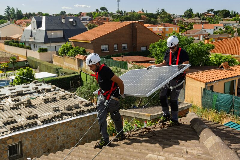 Engineers from Holaluz-Clidom SA fit solar panels to a home in Madrid. Engineers from Holaluz-Clidom SA fit solar panels to a home in Madrid.