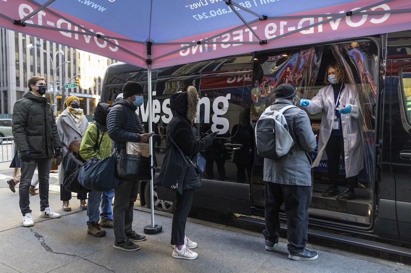 Una fila fuera de un sitio de pruebas móviles de Covid-19, en el barrio de Midtown de Nueva York, el lunes 20 de diciembre de 2021. Una fila fuera de un sitio de pruebas móviles de Covid-19, en el barrio de Midtown de Nueva York, el lunes 20 de diciembre de 2021.