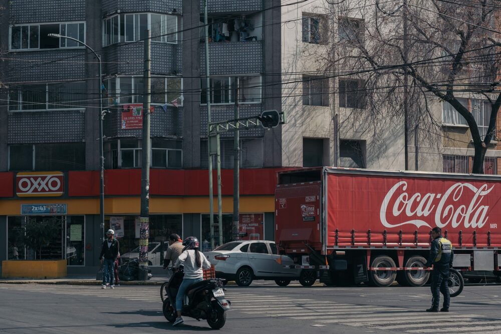 Un camión de reparto de Coca-Cola estacionado frente a una tienda de conveniencia OXXO en la Ciudad de México, México. Un camión de reparto de Coca-Cola estacionado frente a una tienda de conveniencia OXXO en la Ciudad de México, México.
