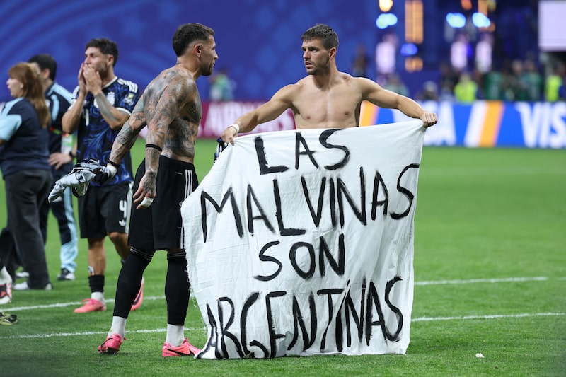 Los argentinos Nicolás Otamendi y Giovani Lo Celso junto a una bandera de un aficionado en la que se lee "Las Malvinas son argentinas". Foto: Thomas Coex/AFP/Getty Images Los argentinos Nicolás Otamendi y Giovani Lo Celso junto a una bandera de un aficionado en la que se lee "Las Malvinas son argentinas". Foto: Thomas Coex/AFP/Getty Images