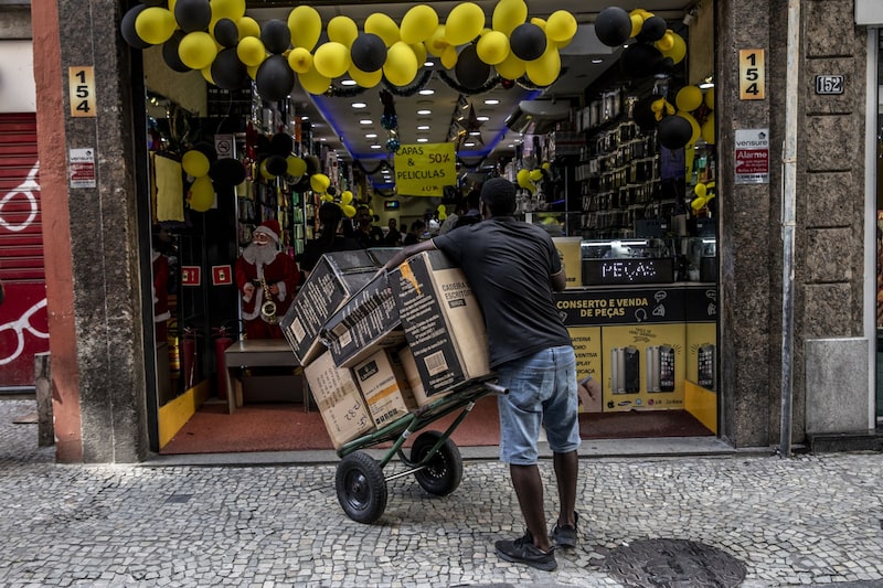 Un trabajador sostiene un carrito de productos frente a una tienda en el Viernes Negro en Río de Janeiro, Brasil, el viernes 25 de noviembre de 2022. Un trabajador sostiene un carrito de productos frente a una tienda en el Viernes Negro en Río de Janeiro, Brasil, el viernes 25 de noviembre de 2022.