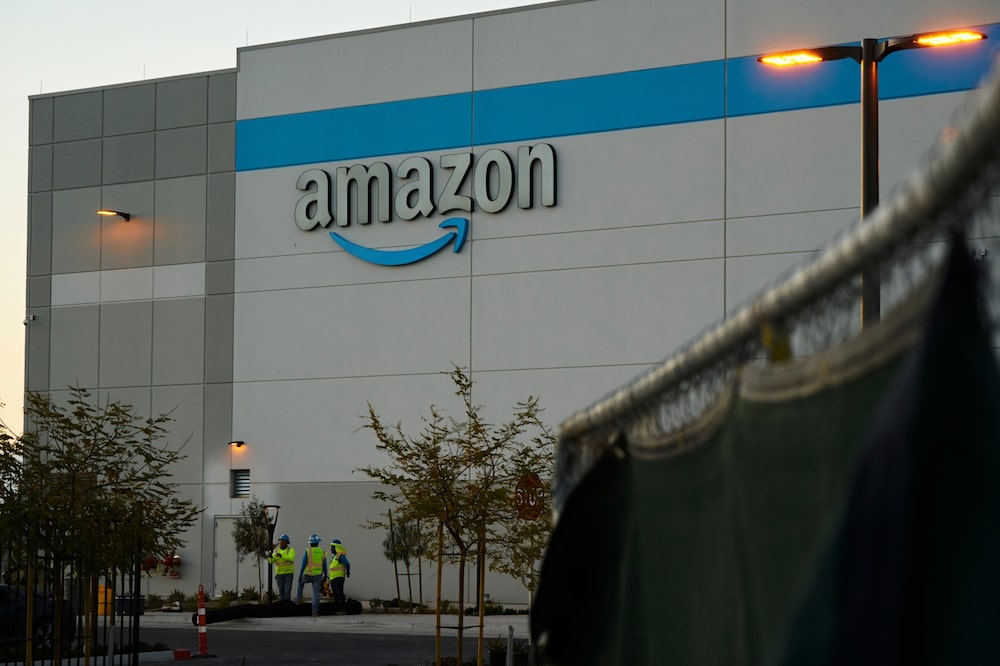 Workers outside an Amazon sort center under construction in San Diego on March 9. Workers outside an Amazon sort center under construction in San Diego on March 9.