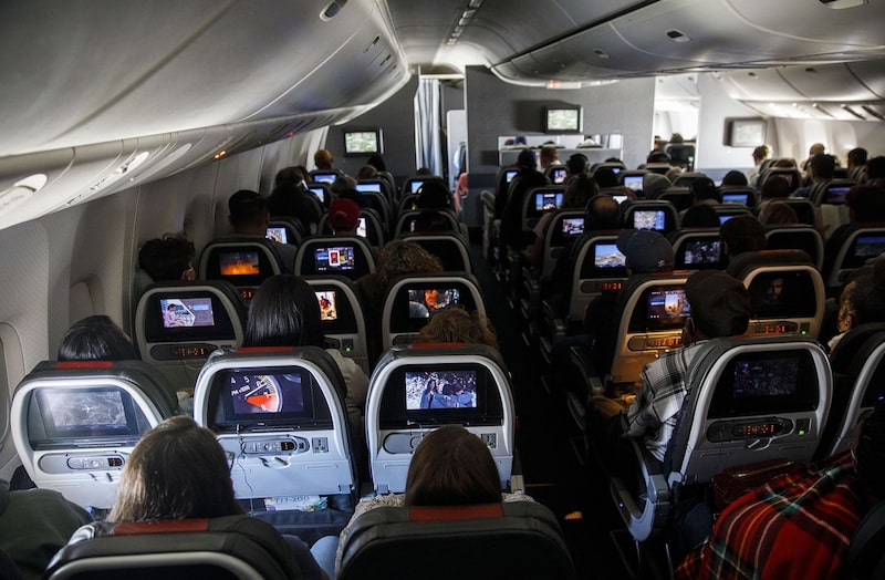 Pasajeros en clase económica durante un vuelo de American Airlines Group Inc. en un Boeing 777-200 Pasajeros en clase económica durante un vuelo de American Airlines Group Inc. en un Boeing 777-200
