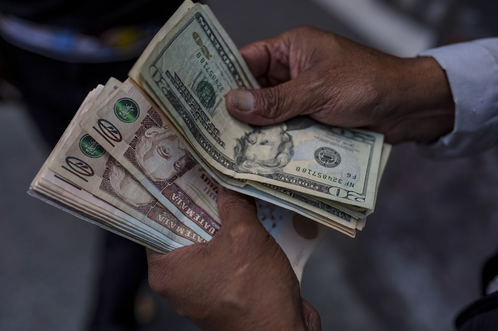 Un cambista cuenta billetes de quetzal y dólar estadounidense en la Ciudad de Guatemala. Fotógrafo: Camilo Freedman/Bloomberg Un cambista cuenta billetes de quetzal y dólar estadounidense en la Ciudad de Guatemala. Fotógrafo: Camilo Freedman/Bloomberg