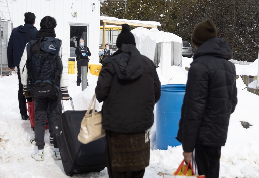 Migrantes hacen cola para entrar en Canadá en un paso informal conocido como Roxham Road en la frontera entre Nueva York y Quebec en marzo de 2023, antes de que fuera cerrado. Migrantes hacen cola para entrar en Canadá en un paso informal conocido como Roxham Road en la frontera entre Nueva York y Quebec en marzo de 2023, antes de que fuera cerrado.