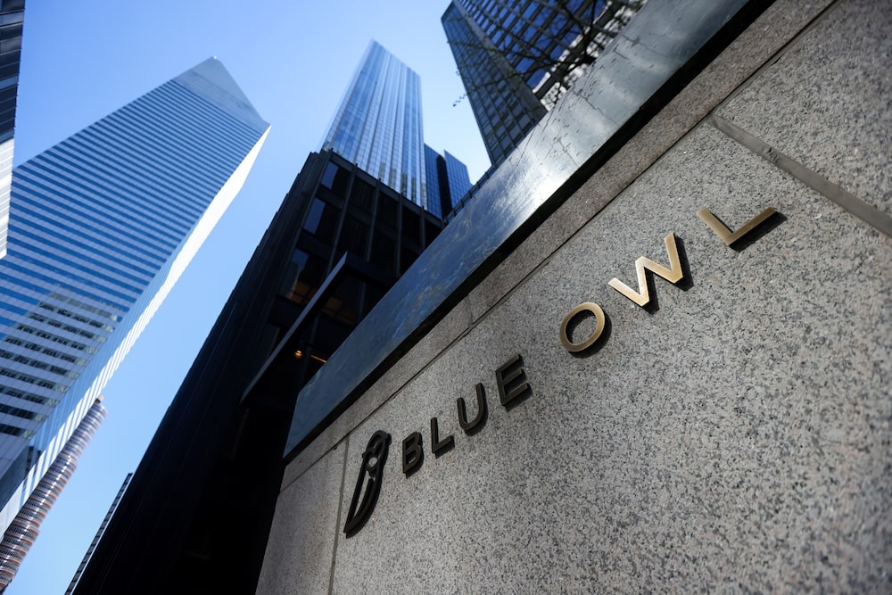 Vista en contrapicado de un edificio de Blue Owl Capital en una zona financiera, con rascacielos de vidrio y acero al fondo. Vista en contrapicado de un edificio de Blue Owl Capital en una zona financiera, con rascacielos de vidrio y acero al fondo.