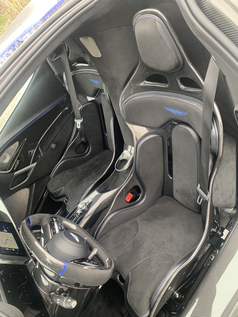 As portas que se abrem para cima e para fora permitem que o motorista entre facilmente nos bancos de fibra de carbono feitos sob medida e acomodem as pernas na cabine sob o volante. Foto: Hannah Elliott/Bloomberg As portas que se abrem para cima e para fora permitem que o motorista entre facilmente nos bancos de fibra de carbono feitos sob medida e acomodem as pernas na cabine sob o volante. Foto: Hannah Elliott/Bloomberg