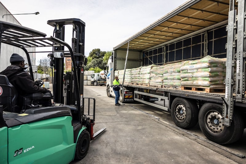 Unos trabajadores descargan sacos de abono para césped de un camión en el almacén del distribuidor mayorista de fertilizantes Agroborges, cerca de Lleida, España. Unos trabajadores descargan sacos de abono para césped de un camión en el almacén del distribuidor mayorista de fertilizantes Agroborges, cerca de Lleida, España.