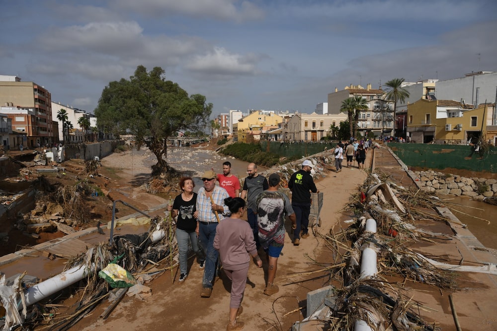 Residentes cruzan un puente a través de montones de escombros tras las inundaciones en Paiporta, Valencia, el 31 de octubre.Fotógrafo: David Ramos/Getty Images Europa Residentes cruzan un puente a través de montones de escombros tras las inundaciones en Paiporta, Valencia, el 31 de octubre.Fotógrafo: David Ramos/Getty Images Europa