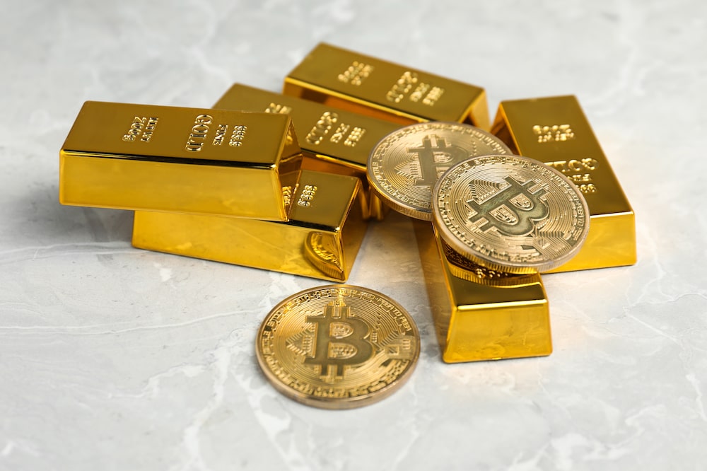 Monedas de bitcoin junto a lingotes de oro. Foto: Shutterstock. Monedas de bitcoin junto a lingotes de oro. Foto: Shutterstock.