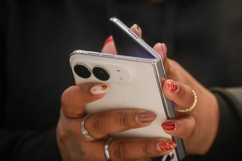 Una clienta sostiene un iPhone Duo en la tienda de Apple de la Quinta Avenida durante el primer día de ventas en tienda en Nueva York, el viernes 23 de octubre de 2026. Una clienta sostiene un iPhone Duo en la tienda de Apple de la Quinta Avenida durante el primer día de ventas en tienda en Nueva York, el viernes 23 de octubre de 2026.