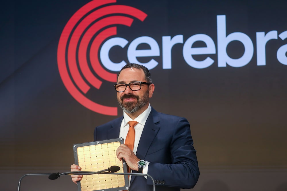 Andrew Feldman, co-founder and chief executive officer of Cerebras Systems Inc., holds the Wafer Scale Engine 3 AI chip during the company's initial public offering (IPO) at the Nasdaq MarketSite in New York, US, on Thursday, May 14, 2026. Cerebras Systems Inc. shares are indicated to open 82% above their listing price, after the artificial intelligence chipmaker raised $5.55 billion in an upsized and hotly anticipated IPO. Photographer: Michael Nagle/Bloomberg Andrew Feldman, co-founder and chief executive officer of Cerebras Systems Inc., holds the Wafer Scale Engine 3 AI chip during the company's initial public offering (IPO) at the Nasdaq MarketSite in New York, US, on Thursday, May 14, 2026. Cerebras Systems Inc. shares are indicated to open 82% above their listing price, after the artificial intelligence chipmaker raised $5.55 billion in an upsized and hotly anticipated IPO. Photographer: Michael Nagle/Bloomberg