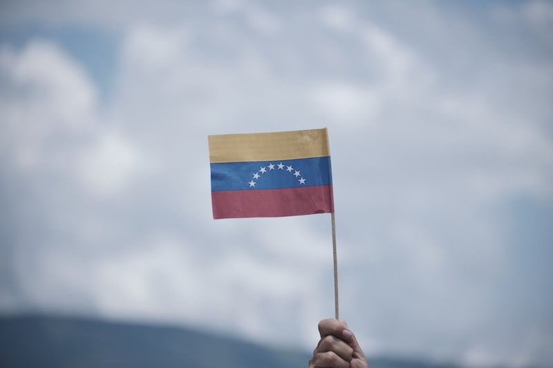 Una persona sostiene una bandera venezolana. Fotógrafo: Ferley Ospina/Bloomberg Una persona sostiene una bandera venezolana. Fotógrafo: Ferley Ospina/Bloomberg