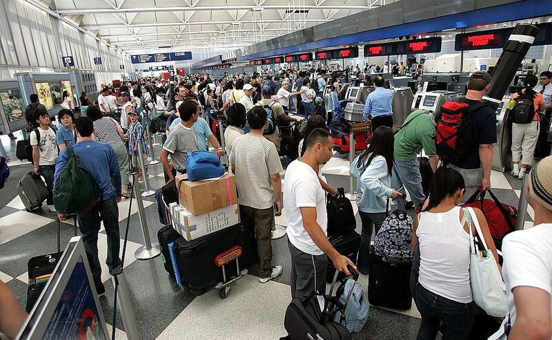 Guichê de aeroporto lotado com dezenas de pessoas em fila Guichê de aeroporto lotado com dezenas de pessoas em fila