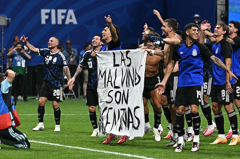 Argentina's players hold a banner reading "The Malvinas (Falkland Islands) belong to Argentina," after winning the 2026 World Cup football tournament semi-final match between England and Argentina at the Atlanta Stadium in Atlanta on July 15, 2026. (Photo by Paul ELLIS / AFP via Getty Images) Argentina's players hold a banner reading "The Malvinas (Falkland Islands) belong to Argentina," after winning the 2026 World Cup football tournament semi-final match between England and Argentina at the Atlanta Stadium in Atlanta on July 15, 2026. (Photo by Paul ELLIS / AFP via Getty Images)