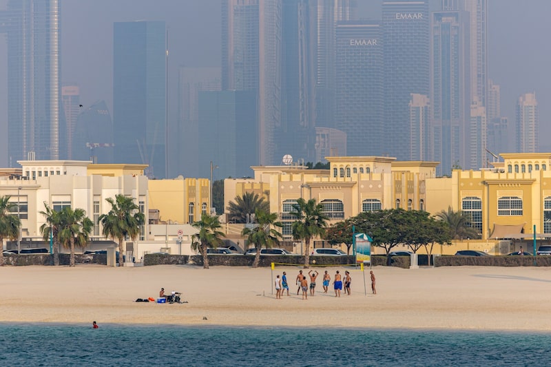 Unos bañistas juegan voleibol, con las viviendas y los rascacielos comerciales como telón de fondo, en el distrito de Jumeirah Beach de Dubai, Emiratos Árabes Unidos, el viernes 25 de agosto de 2023. Unos bañistas juegan voleibol, con las viviendas y los rascacielos comerciales como telón de fondo, en el distrito de Jumeirah Beach de Dubai, Emiratos Árabes Unidos, el viernes 25 de agosto de 2023.