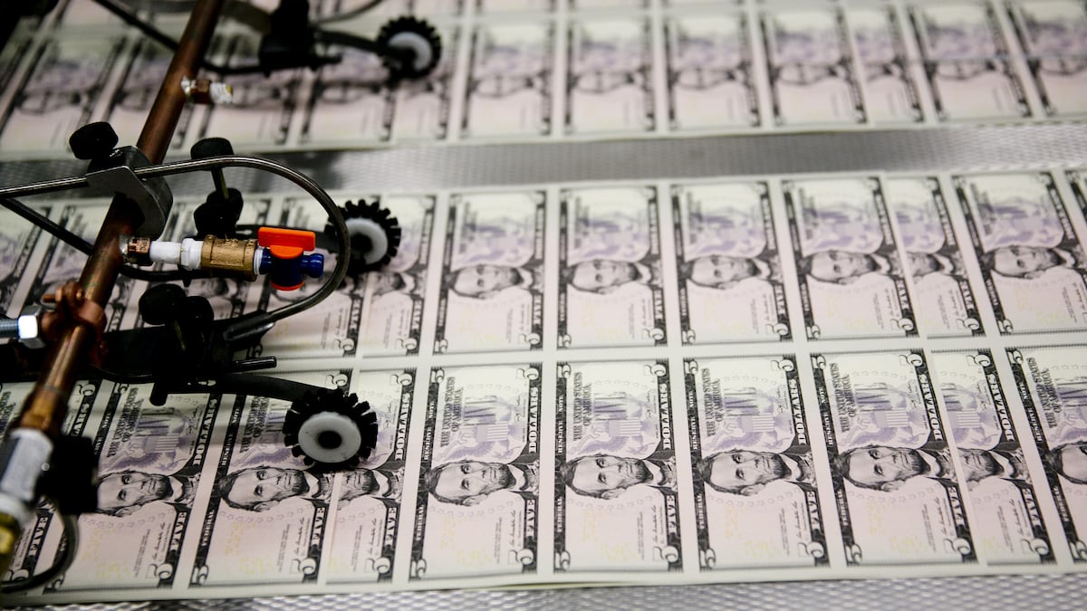 Hojas de billetes de cinco dólares pasan por una máquina para recibir el número de serie y los sellos del Departamento del Tesoro y de la Reserva Federal de EE.UU. en la Oficina de Grabado e Impresión de Washington D.C.