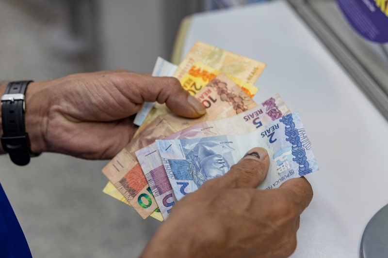 A customer counts Brazilian real banknotes at a Caixa Econmica lottery agency in Sao Paulo, Brazil, on Monday, Oct. 5, 2026. Brazilian assets surged after Senator Flavio Bolsonaro defied polls and became the front-runner to win the Oct. 25 presidential runoff against Luiz Inacio Lula da Silva. Photographer: Victor Moriyama/Bloomberg A customer counts Brazilian real banknotes at a Caixa Econmica lottery agency in Sao Paulo, Brazil, on Monday, Oct. 5, 2026. Brazilian assets surged after Senator Flavio Bolsonaro defied polls and became the front-runner to win the Oct. 25 presidential runoff against Luiz Inacio Lula da Silva. Photographer: Victor Moriyama/Bloomberg