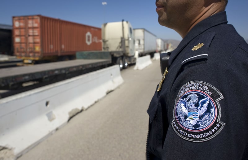 A U.S. Customs and Border Protection (CBP) officer stands next to a line of trucks entering from Mexico at the Otay Mesa Cargo Port of Entry in San Diego, California, U.S., on May 23, 2017. The skirmish among House Ways and Means Committee Republicans over a border tax provision resurfaced during a May 24 hearing where Treasury Secretary Steven Mnuchin was testifying on the president's proposed fiscal year 2018 budget. Photographer: David Maung/Bloomberg A U.S. Customs and Border Protection (CBP) officer stands next to a line of trucks entering from Mexico at the Otay Mesa Cargo Port of Entry in San Diego, California, U.S., on May 23, 2017. The skirmish among House Ways and Means Committee Republicans over a border tax provision resurfaced during a May 24 hearing where Treasury Secretary Steven Mnuchin was testifying on the president's proposed fiscal year 2018 budget. Photographer: David Maung/Bloomberg