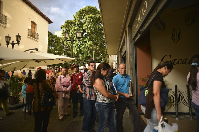 Customers wait in line at Cacao Venezuela, a state-owned chocolate shop that sells government-subsidized chocolate products in downtown Caracas, Venezuela on Monday, Jan. 14, 2013. Photographer: Meridith Kohut/Bloomberg Customers wait in line at Cacao Venezuela, a state-owned chocolate shop that sells government-subsidized chocolate products in downtown Caracas, Venezuela on Monday, Jan. 14, 2013. Photographer: Meridith Kohut/Bloomberg