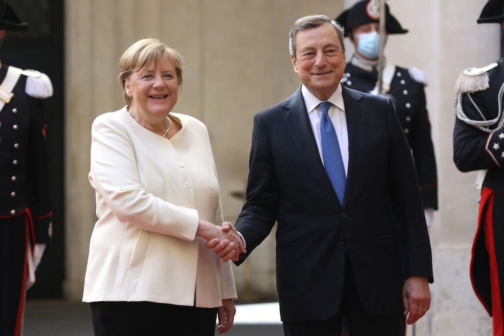 Mario Draghi, primer ministro de Italia, a la derecha, con Angela Merkel, canciller de Alemania, se dan la mano antes de su reunión en el Palacio Chigi en Roma, Italia, el jueves 7 de octubre de 2021 Fotógrafa: Alessia Pierdomenico/Bloomberg Mario Draghi, primer ministro de Italia, a la derecha, con Angela Merkel, canciller de Alemania, se dan la mano antes de su reunión en el Palacio Chigi en Roma, Italia, el jueves 7 de octubre de 2021 Fotógrafa: Alessia Pierdomenico/Bloomberg
