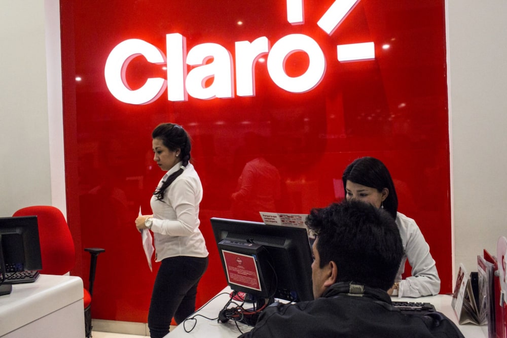 Empleados atienden a clientes en una tienda de América Móvil SAB Claro Colombia en Bogotá. Empleados atienden a clientes en una tienda de América Móvil SAB Claro Colombia en Bogotá.