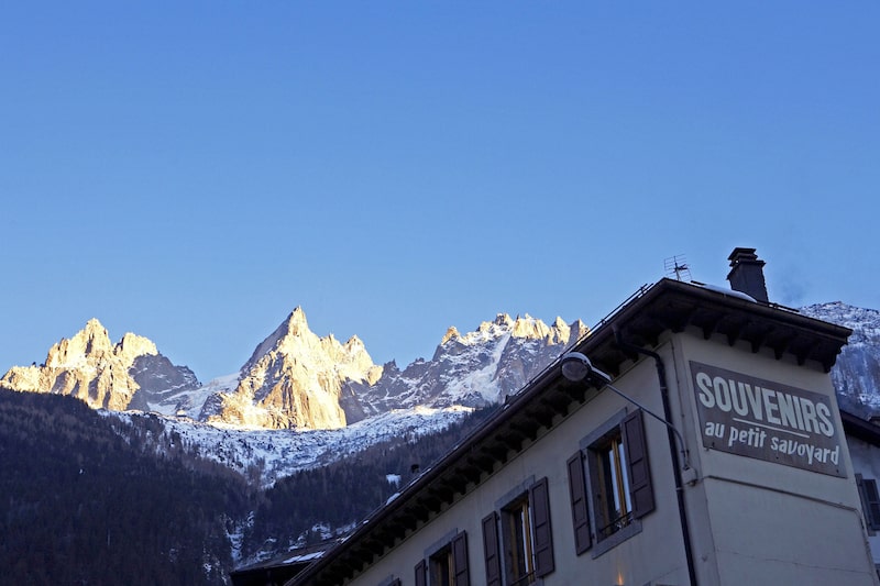 Lojinha de souvenirs em primeiro plano. Ao fundo, uma montanha coberta de neve Lojinha de souvenirs em primeiro plano. Ao fundo, uma montanha coberta de neve